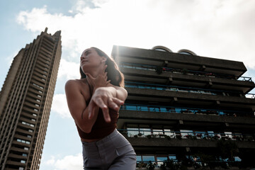Dancer performing in front of barbican estate buildings in london