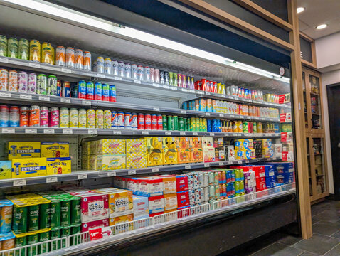Canada, Quebec, 30 November 2025 : Cans and boxes of colorful beverages fill grocery store fridge