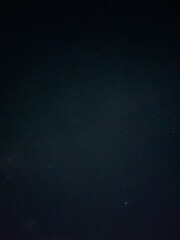 Vertical composition of dark night sky with subtle stars, suitable for abstract space background and astronomy themes.