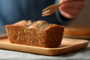 Delicious homemade banana bread or cake on rustic wooden plate