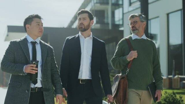 Group moving with intention, Three individuals walk together discussing their upcoming meeting plans