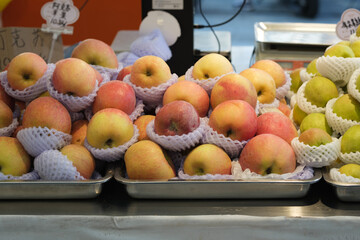 Fresh, bright red apples are displayed in bulk on the market shelves.