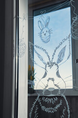 Zero cost responsible holiday decor economically driven. Painted Easter bunny rabbit on window glass indoor at home. Affordable alternative Easter springtime seasonal tradition ideas decoration. Diy