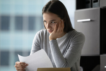 Nervous over letter. Stressed confused millennial businesswoman office worker student sit at desk...
