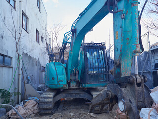冬の街の住宅街の家を解体する重機とゴミの様子