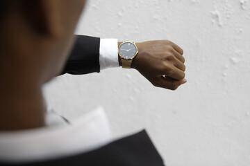 Side view of man wearing elegant gold wristwatch, symbolizing modern business fashion, confidence, time management, and professional lifestyle.
