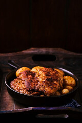 Fried chicken breast with potatoes. Rustic wooden background. Soft focus.