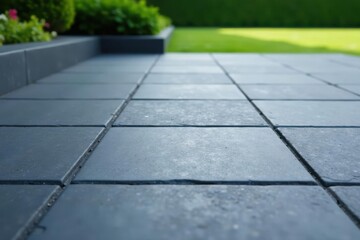 Obraz premium Serene Backyard Patio Dark Gray Stone Tiles Leading to Lush Green Lawn