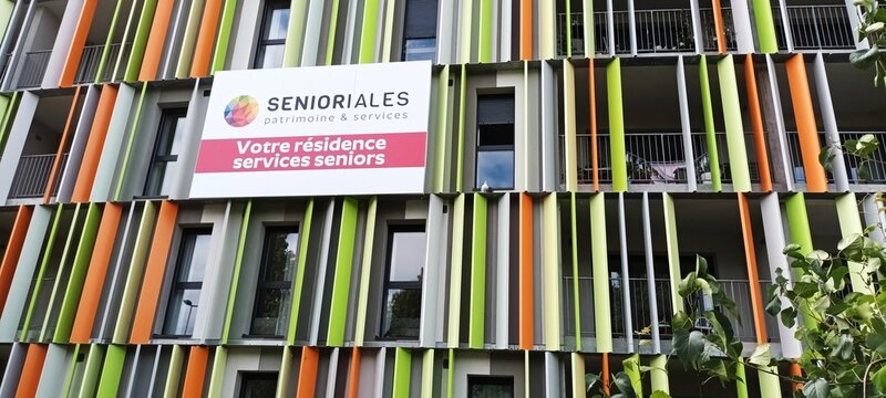 The modern facade of a charming nursing home in France. Colorful modern building facade with signage for seniors' residence  