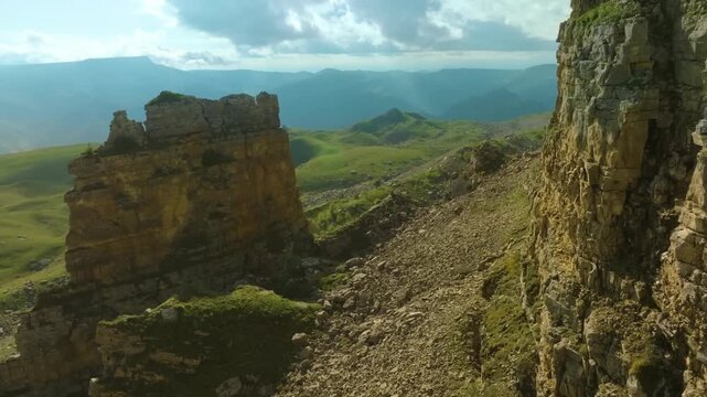 Panoramic view of the majestic Bermamyt Plateau in the Karachay-Cherkessia Republic, Russia, featuring lush green landscapes, steep rock cliffs, and dramatic mountain scenery under a partly cloudy sky