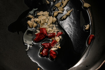 ニンニクと唐辛子をオリーブオイルで炒める様子