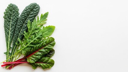 Fresh leafy greens including kale, arugula, and swiss chard on a white background. Top view flat lay of healthy raw vegetables with copy space for text