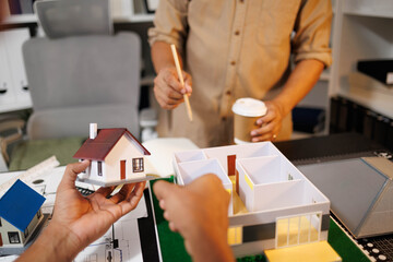 
Two people are working on a house plan design. They are using various tools, working with the...