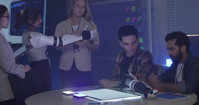 Diverse group of engineers and designers collaborates on development of robotic prosthetic arm in high-tech innovation lab. Capturing teamwork, technological creativity, human-centered product design

