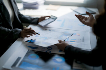 Businesswomen analyzing financial data, discussing investment strategy in office