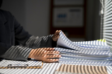 Business person working on stack of documents in office
