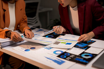 Businesswomen analyzing financial data, graphs, and charts