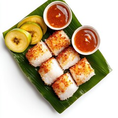 Delicious coconut crusted fish served with plantains and dipping sauce displayed on a vibrant green banana leaf against a bright white background, a culinary delight.