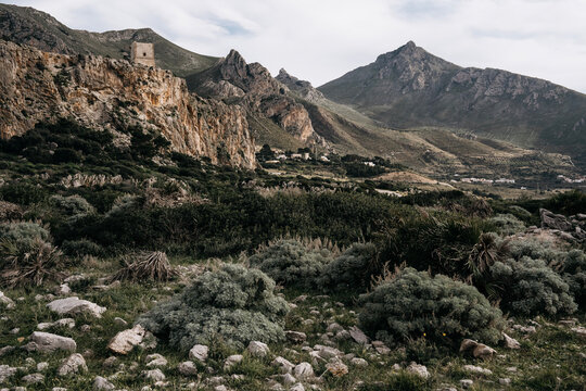 Torre Isulidda Near San Vito Lo Capo In Sicily: Historic Coastal Watchtower With Rugged Limestone Mountains And Southern Rock Climbing Cliffs In Natural Mediterranean Landscape