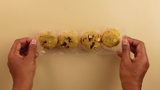 Hands open cookie package to reveal tasty treats