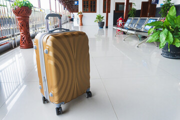 A yellow suitcase in an empty train station. Travel Concept.