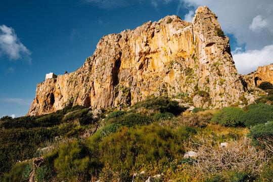 Torre Isulidda Near San Vito Lo Capo In Sicily: Historic Coastal Watchtower With Rugged Limestone Mountains And Southern Rock Climbing Cliffs In Natural Mediterranean Landscape