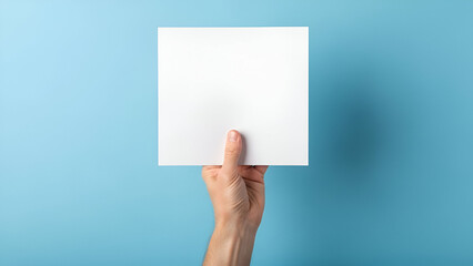 Fototapeta premium Blank white card presentation held by a hand on a light blue background showcase your project with