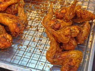 Close-up view of crispy fried chicken wings displayed on a cooling rack.