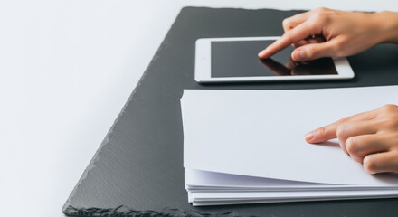 Hands Working on Tablet and Paper Documents on a Desk