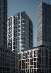 Obraz premium Skyscrapers with Reflected Windows Against Clear Blue Sky