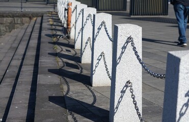 Symmetrical perspective of stone posts and shadows on a paved path