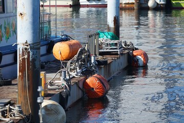 Industrial maritime equipment at a harbor with calm water reflections