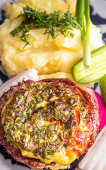 Baked meat with cheese and mashed potatoes with fresh vegetables as a side dish