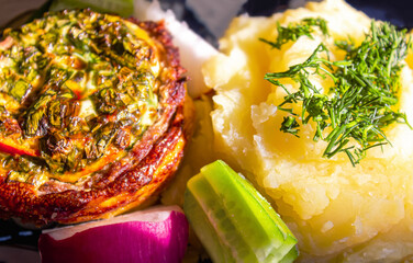 Baked meat with cheese and mashed potatoes with fresh vegetables as a side dish