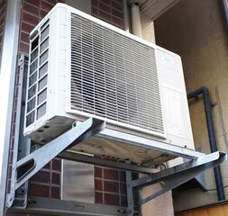 Outdoor air conditioning unit mounted on a tiled exterior wall