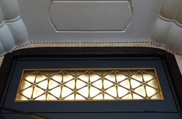 Decorative clerestory window with patterns on the upper wall of an old building