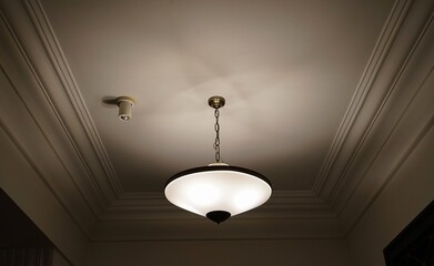 Warm glow from an indoor light fixture suspended from the ceiling