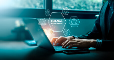 Change management concept with businessman using laptop and virtual interface icons representing leadership, teamwork, strategy, and learning for organizational transformation and business improvement
