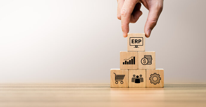 ERP enterprise resource planning concept with wooden block pyramid showing business management modules including finance, sales, human resource, supply chain, and operation integration for efficiency