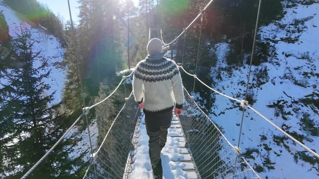 Man in Iceland Sweater Walking Through Snowy Forest in Switzerland Drone shot