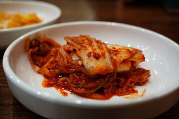 Spicy Korean kimchi in a white bowl, a traditional fermented side dish