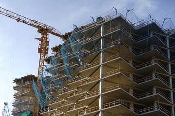 Tower Crane Operating at High-Rise Monolithic Residential Building Construction Site