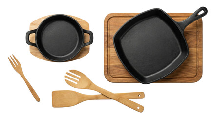Cast iron pans and wooden kitchen utensils on cutting boards, isolated on white