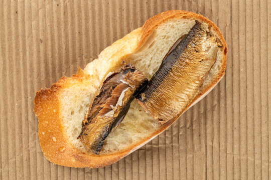 Sprat sandwich on kraft paper, top view, macro.