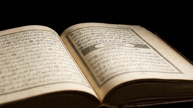 A serene close-up shot features an open, aged book displaying intricate Arabic script on its warm, beige pages. The traditional calligraphy and ornate borders of the text are meticulously detailed, su