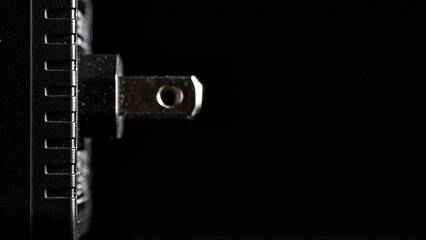 Close up of a metal socket wrench head on a black background.