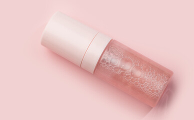 Lotion, skin care beauty product in a glass bottle on pink background, top view, flat lay. Make up, moisturizer. Body fluid, beauty serum, peptides, essence, wellness ads, cosmetic presentations 