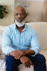 Portrait of african american senior man sitting on couch at home