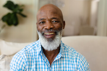 Portrait of african american senior man smiling while sitting on the couch at home