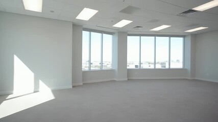 Empty modern office space with large windows and natural light.